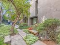 Tranquil courtyard with lush greenery, mature trees, bench, and seating area for relaxation at 1070 Race St # H, Denver, CO 80206