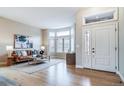 Inviting living room featuring hardwood floors, a cozy leather sofa, and an abundance of natural light at 4532 Christensen Cir, Littleton, CO 80123