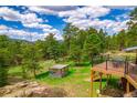 Serene backyard featuring a cozy chicken coop and a spacious deck with scenic views of the lush landscape at 8838 Hillview Rd, Morrison, CO 80465