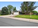 Charming single-Gathering home featuring a manicured lawn, brick accents, and an attached two-car garage at 2495 S Lansing Way, Aurora, CO 80014