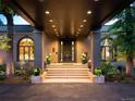 This covered entryway features concrete steps leading to double doors, flanked by large windows and potted plants at 9 Sedgwick Dr, Englewood, CO 80113