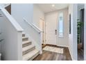 Bright entryway featuring hard surface flooring, white trim, and an adjacent carpeted stairway at 14151 Deertrack Ln, Parker, CO 80134