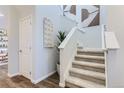 Carpeted stairway with white painted banister and trim, and a decorative accent wall at 14151 Deertrack Ln, Parker, CO 80134