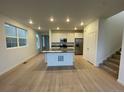 Bright, open-concept kitchen with island, stainless steel appliances and hardwood flooring at 6739 Juniper Dr, Thornton, CO 80602