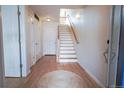 Inviting entryway with hardwood floors, white doors, stairs, and a round rug at 451 S Reed St, Lakewood, CO 80226