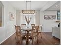 Dining area features a round wooden table, chandelier lighting, and plenty of natural light at 18079 E 108Th Pl, Commerce City, CO 80022