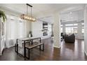 Open-concept dining area featuring a modern light fixture, bench seating, and seamless flow into the living space at 18079 E 108Th Pl, Commerce City, CO 80022