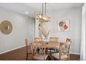 Dining area features a round wooden table, chandelier lighting, and plenty of natural light at 18079 E 108Th Pl, Commerce City, CO 80022