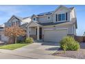 Inviting two-story home with a well-maintained lawn and a two-car garage with grey sidings at 18079 E 108Th Pl, Commerce City, CO 80022