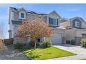 Charming two-story home with a well-maintained lawn and a two-car garage with grey sidings at 18079 E 108Th Pl, Commerce City, CO 80022