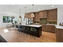 Spacious kitchen featuring a large island with seating and elegant lighting and hardwood floors at 2450 S Cherokee St, Denver, CO 80223