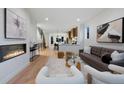Bright open-concept living area with fireplace, light-colored wooden floors, and modern furniture at 2450 S Cherokee St, Denver, CO 80223
