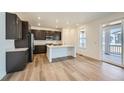 Modern kitchen featuring dark cabinets, white countertops, stainless steel appliances, and a center island at 4619 Windmill Dr, Brighton, CO 80601