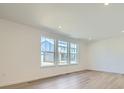 Spacious room with recessed lighting, hardwood floors and large windows looking out onto the neighborhood at 4619 Windmill Dr, Brighton, CO 80601
