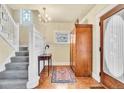 Bright entryway with hardwood floors, decorative windows, and a classic staircase with detailed woodwork at 377 S Grant St, Denver, CO 80209