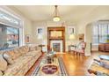 Cozy living room featuring hardwood floors, a decorative fireplace, and ample natural light from large windows at 377 S Grant St, Denver, CO 80209