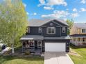 Inviting two-story home with a covered front porch, hanging flowers, and manicured landscaping at 5249 Mt Arapaho Cir, Frederick, CO 80504