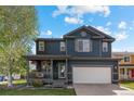Two-story home features covered front porch, hanging flower baskets and an attached two-car garage at 5249 Mt Arapaho Cir, Frederick, CO 80504