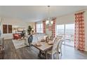 Dining area adjacent to living room with seating for six and sliding glass door access to balcony at 6513 14Th St, Frederick, CO 80530