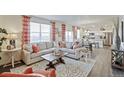 Open living area with a large sectional sofa and a view into the kitchen and dining space at 6513 14Th St, Frederick, CO 80530