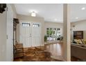 Bright foyer with hardwood floors, a large window, and an elegant entryway bench at 7773 Gunsight Pass, Littleton, CO 80127