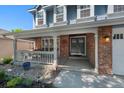 Charming front porch featuring brick accents and a cozy sitting area with ample natural light at 7773 Gunsight Pass, Littleton, CO 80127