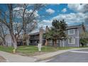 Condominium exterior with gray siding, stone accents, wooden balconies, and well-maintained landscaping at 3494 S Eagle St # 202, Aurora, CO 80014