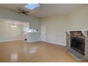 Spacious open layout living room featuring a ceiling fan, skylight, fireplace, and an open view of the kitchen at 3494 S Eagle St # 202, Aurora, CO 80014