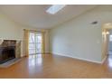 Bright living room featuring wood floors, stone fireplace, skylight, and sliding glass doors to the outside balcony at 3494 S Eagle St # 202, Aurora, CO 80014