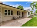 Inviting front porch area with neutral brick, cozy seating, and hanging flower baskets at 3865 Independence Ct, Wheat Ridge, CO 80033