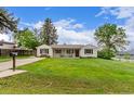 Charming one-story home featuring a well-manicured lawn and inviting covered porch at 3865 Independence Ct, Wheat Ridge, CO 80033