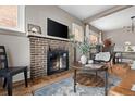 Bright living room featuring a brick fireplace, flat screen TV and stylish decor at 3725 Federal Blvd, Denver, CO 80211