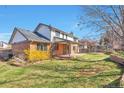 Large backyard featuring a well-maintained lawn, covered patio, brick accents, and mature trees at 8055 S Zephyr Way, Littleton, CO 80128