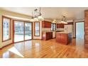 Open kitchen and dining area featuring hardwood floors, warm wood cabinets, and a sliding glass door to the backyard at 8055 S Zephyr Way, Littleton, CO 80128