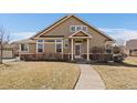 Inviting home exterior featuring a cozy front porch, well-manicured lawn, and classic architectural details at 10441 W Remington Dr, Littleton, CO 80127