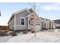Two-story craftsman home with gray siding, snowy landscaping, and a two-car garage at 838 N Yantley St, Aurora, CO 80018