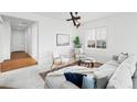 Open concept living room with sectional sofa, hardwood floors, and access to hallway at 838 N Yantley St, Aurora, CO 80018