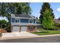Beautiful home with a driveway leading to the two-car garage and solar panels, set against a backdrop of lush greenery at 3767 E Phillips Cir, Centennial, CO 80122