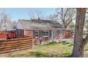 Brick home featuring well-maintained lawn, privacy fence, chairs, and a bird bath on the front patio at 7785 E 13Th Ave, Denver, CO 80220