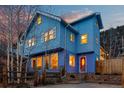Exterior of a blue home displaying unique architectural elements and a vibrant red front door at 2041 Virginia St, Idaho Springs, CO 80452