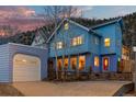 Exterior of a blue home with a detached garage, set against a backdrop of twilight sky at 2041 Virginia St, Idaho Springs, CO 80452