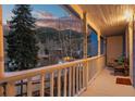 Cozy porch featuring mountain views, white railings, a sitting area, and exterior lighting at 2041 Virginia St, Idaho Springs, CO 80452
