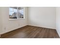 Inviting bedroom with laminate flooring and a large window offering bright, natural light at 760 N Deer Park St, Watkins, CO 80137