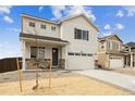 Charming two-story home featuring a stone-accented porch and an attached two-car garage at 760 N Deer Park St, Watkins, CO 80137