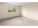 Bright bedroom with neutral carpet, a large window, and fresh paint providing ample natural light at 8487 W 62Nd Pl, Arvada, CO 80004