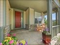 Charming front porch with stone accents, offering a cozy space with seating and colorful potted flowers at 10565 Kicking Horse Dr, Littleton, CO 80125
