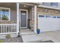 Charming covered porch leads to the front door with a view of the attached three-car garage at 7702 E 159Th Ave, Thornton, CO 80602
