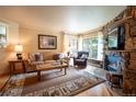 Cozy living room with a stone fireplace, comfortable seating, and natural light at 765 Columbine St # C203, Breckenridge, CO 80424