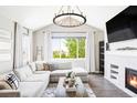 Bright and airy living room with a large window, comfortable sectional, and modern fireplace at 16300 Paris Way, Brighton, CO 80602