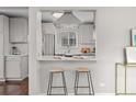 View of the updated kitchen with stainless steel appliances and breakfast bar seating at 2950 Hudson St, Denver, CO 80207